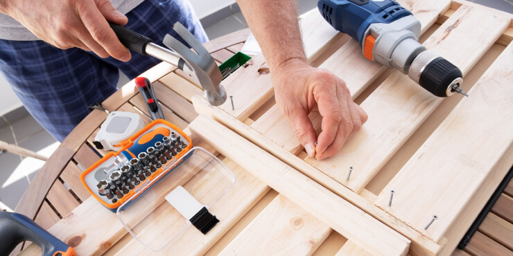 b3 Hands driving nail with hammer into wooden shelf - www.freepik.com